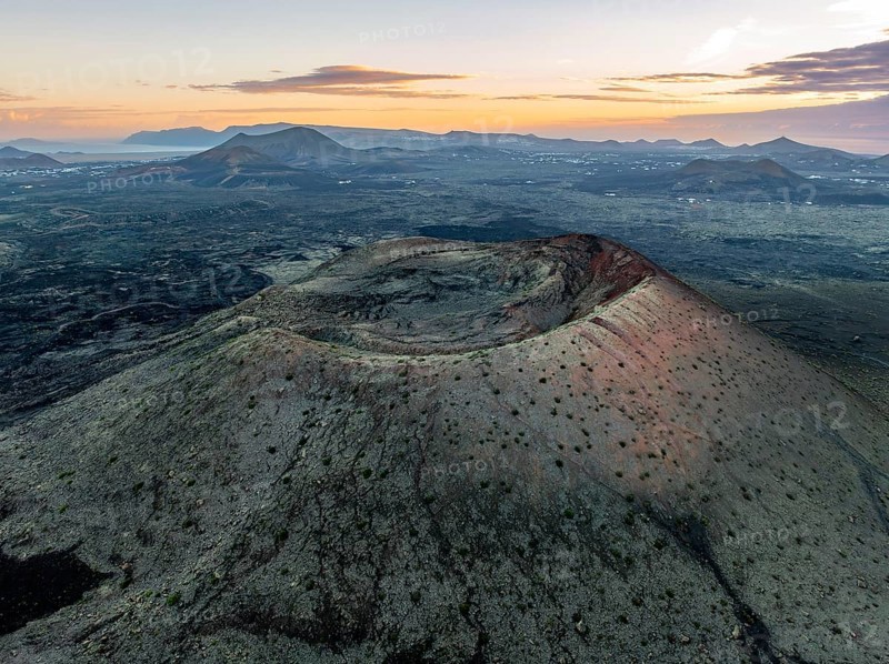Caldera Colorada volcano, picturesque volcanic landscape with volcanic crater at sunrise, Parque Natural de Los Volcanes, aerial view, Lanzarote, Canary Islands, Spain
