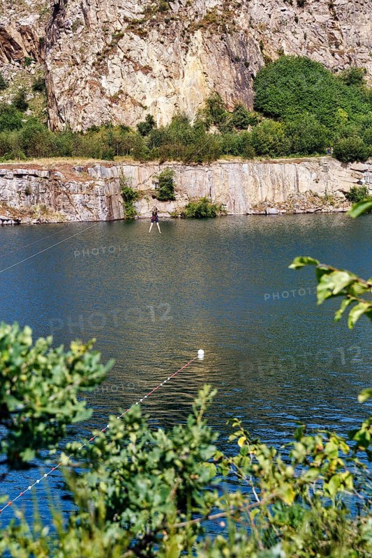 Tourist on a zip line across the lake, Opal Lake in the granite quarry, MoselleÃ¸kken Stenbrudsmuseum, museum in the quarry, Hammerknuden, Allinge-Sandvig, Bornholm, Denmark