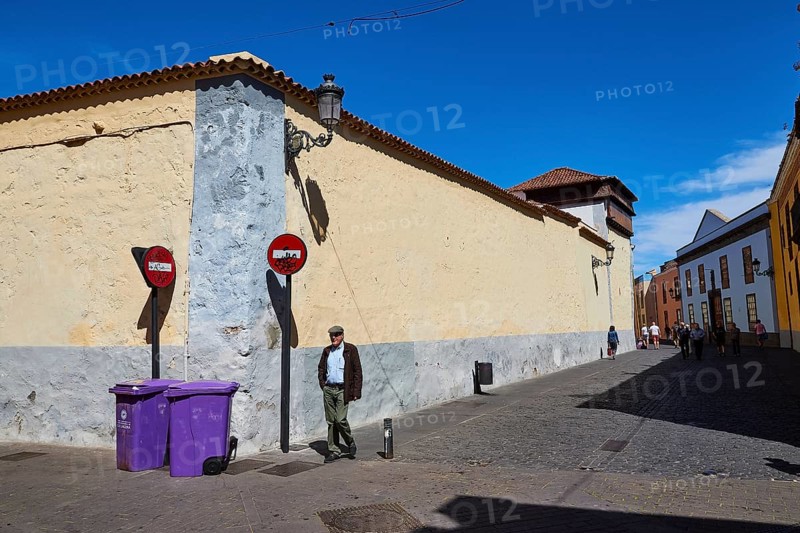 Street scene with man, signs and historic buildings under clear sky, UNESCO World Heritage Old Town of San Crstobal de La Laguna, La Laguna, Tenerife, Canary Islands, Spain