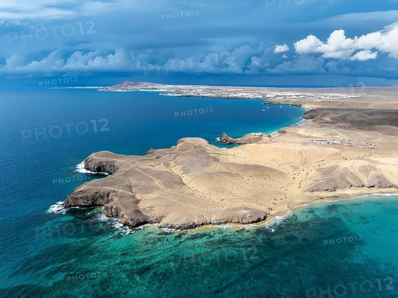Coast with Playa de Papagayo beach and Playa Caleta del Congrio and blue sea, dry landscape of Los Ajaches Natural Park, aerial view, Lanzarote, Canary Islands, Spain