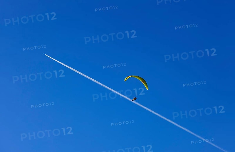 Paragliders with contrails in the blue sky, Osterhorn Group, Salzkammergut, Province of Salzburg, Austria