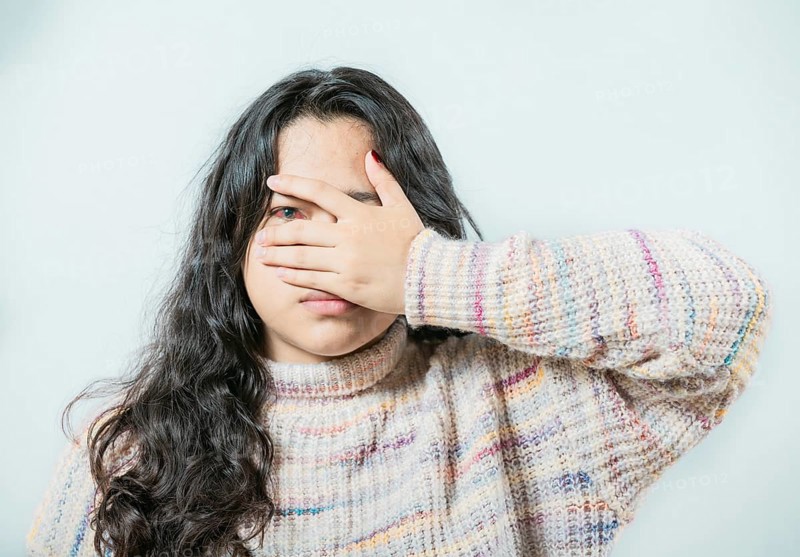 Close up of woman with conjunctivitis isolated. Female with eye infection looking at camera