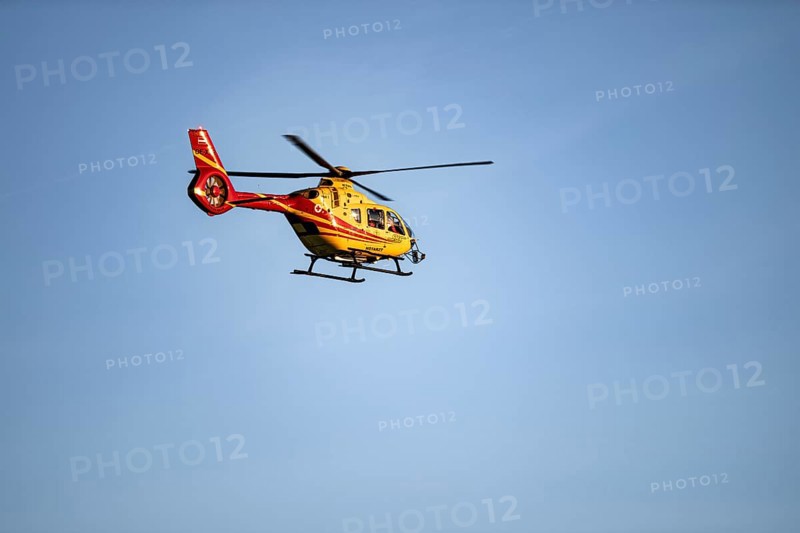 Rescue helicopter flying against a blue sky, Tyrol, Austria