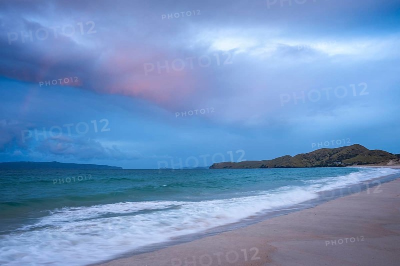 Landscape with sea and sandy beach in New Zealand in the evening at sunset. Otama Beach, Coromandel Peninsula, Waikato, New Zealand