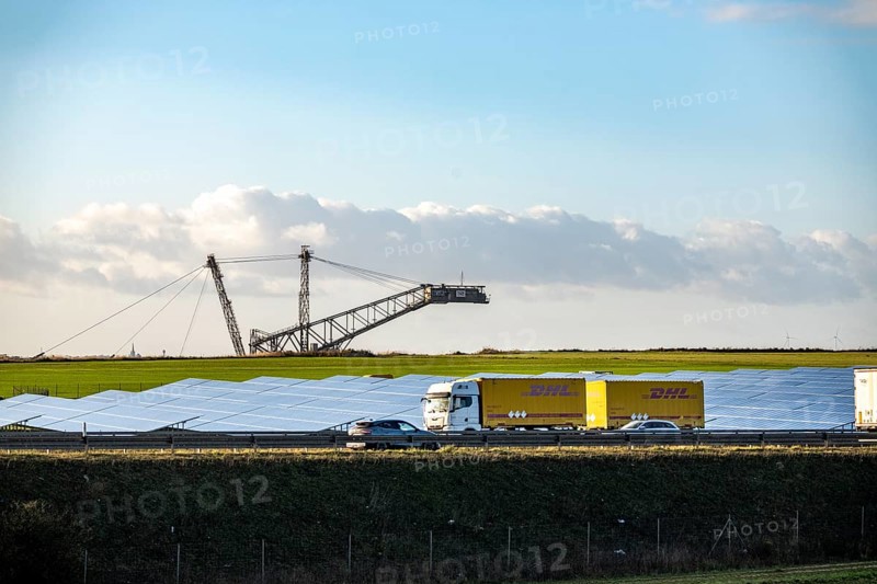 86.5 MW peak open space photovoltaic systems, from RWE, with over 141, 000 solar modules, on a side strip, along the A44 motorway near JÃ¼chen, on the timber triangle, recultivated open-cast mining site, excavator in the Garzweiler lignite mine, North Rhine-Westphalia, Germany