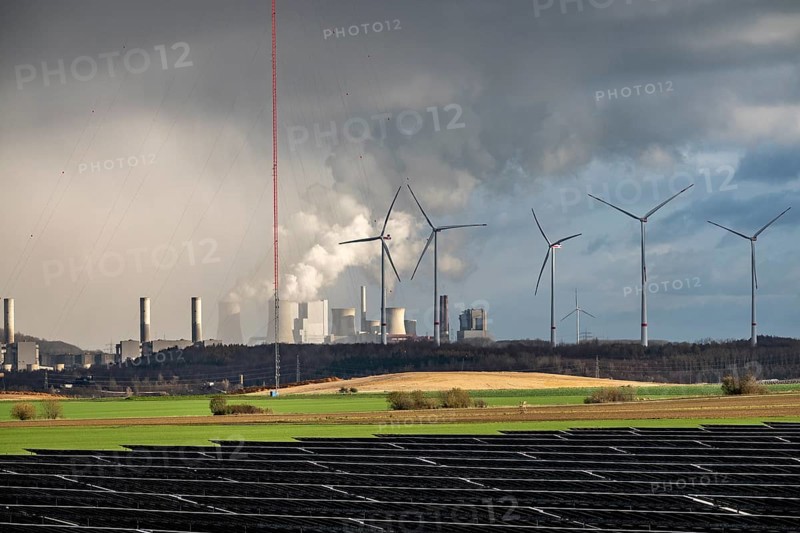 86.5 MW peak open space photovoltaic systems, from RWE, with over 141, 000 solar modules, on a side strip, along the A44 motorway near JÃ¼chen, at the timber triangle, recultivated open-cast mining site, in the background RWE Neurath lignite power plant, wind farm, North Rhine-Westphalia, Germany
