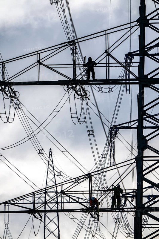Work on a 380 kV high-voltage overhead line, new construction, along the A57 motorway, near Meerbusch, workers on the boom of the high-voltage pylon, North Rhine-Westphalia, Germany