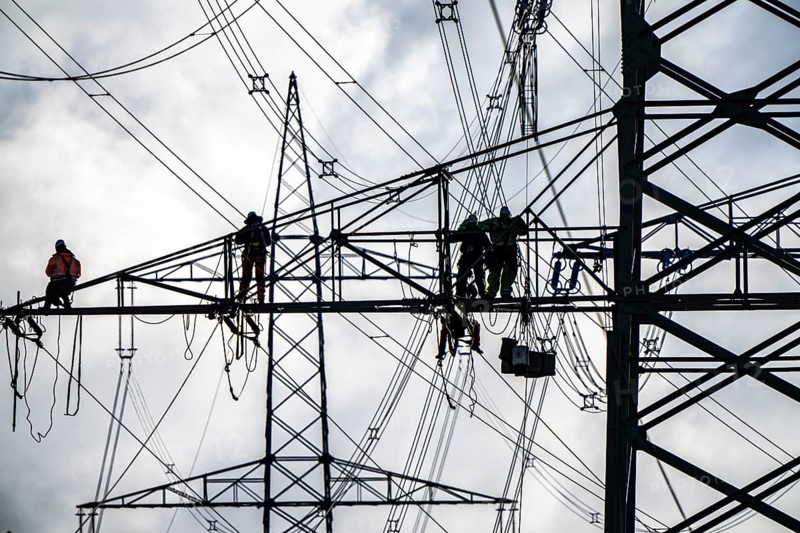Work on a 380 kV high-voltage overhead line, new construction, along the A57 motorway, near Meerbusch, workers on the boom of the high-voltage pylon, North Rhine-Westphalia, Germany
