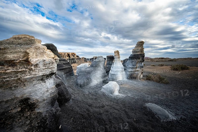 Eroded rock formations, volcanic landscape with dramatic cloudy skies, Ciudad Estratificada or Los Roferos, Antigua Rofera de Teseguite, Lanzarote, Canary Islands, Spain