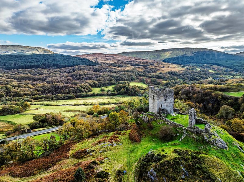 Autumn colours over Castell Dolwyddelan and Eryri Mountains from a drone, Snowdonia, Conwy County Borough, Wales, England, United Kingdom