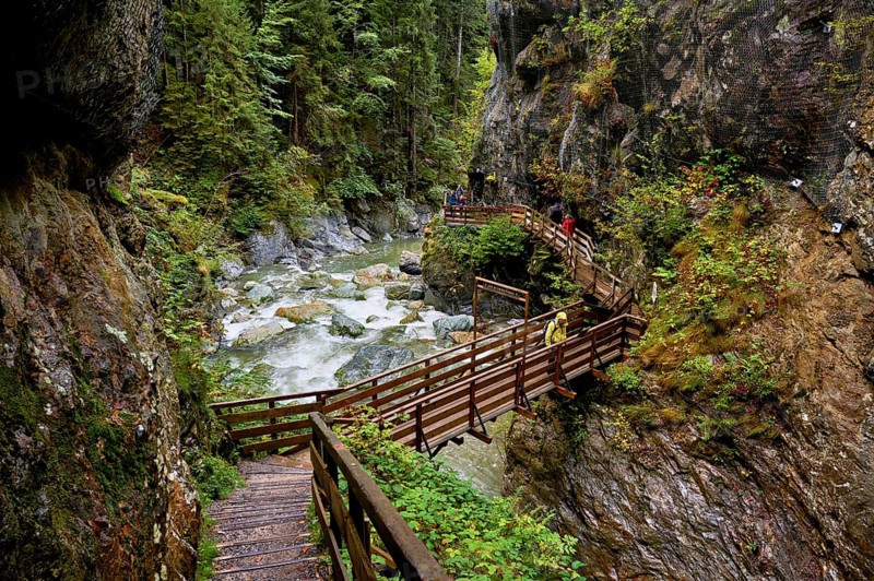 People on wooden walkway on the Diosaz mountain river in the gorge, Gorges de la Diosaz, Les Houches, Chamonix-Mont-Blanc, Haute-Savoie, France