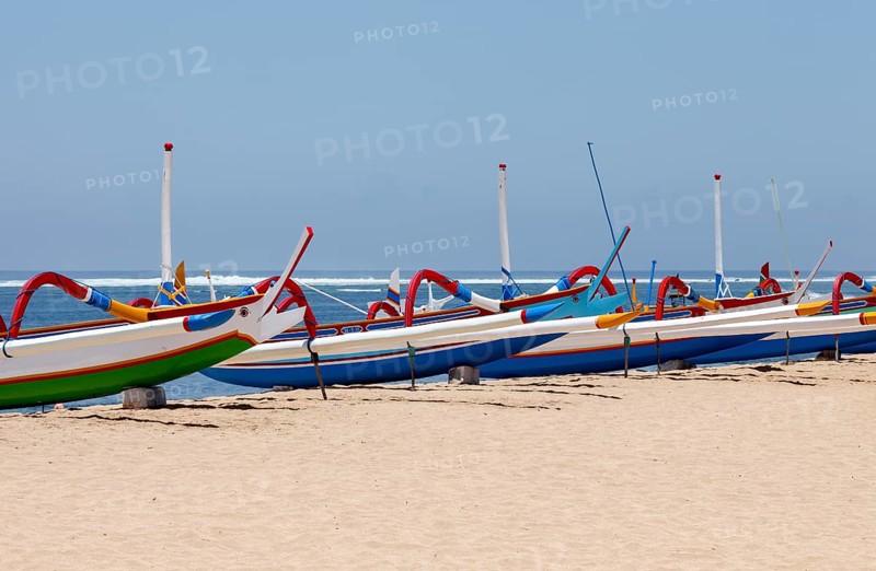 Colourfully painted outrigger fishing boats, (Junkung), on Sanur beach, Bali, Indonesia