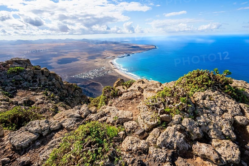Castillejo viewpoint, view from the Risco de Famara cliffs to the coast and the sea with Famara beach, Playa de Famara with La Calaeta, Lanzarote, Canary Islands, Spain