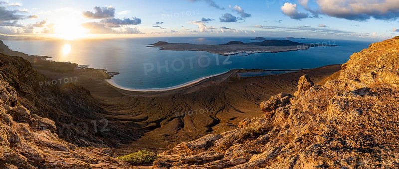 View of steep cliffs to sea and the island of La Graciosa, Mirador del Porrito viewpoint at sunset, Lanzarote, Canary Islands, Spain