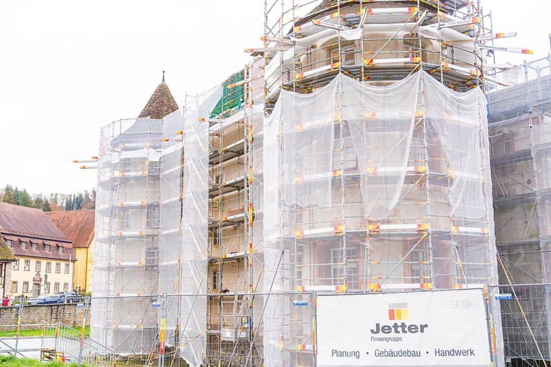 Side of a building with several towers surrounded by large scaffolding for restoration, Wasserschloss Glatt, Sulz, Germany