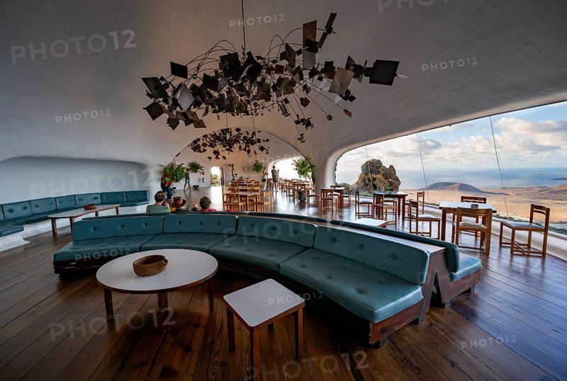 Sitting area with large sofa in the cafe with panoramic window, interior at the Mirador del RÃ­o viewpoint, designed by artist César Manrique, Lanzarote, Canary Islands, Spain