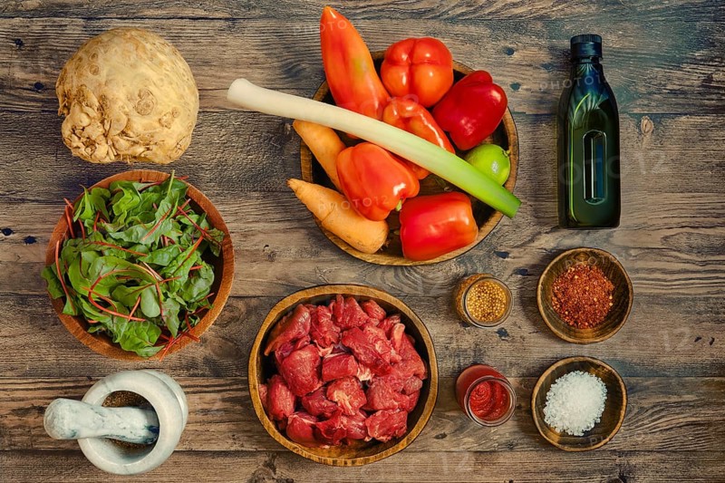 A vibrant assortment of fresh ingredients arranged on a wooden tabletop, illustrating healthy cooking or farm-to-table goods