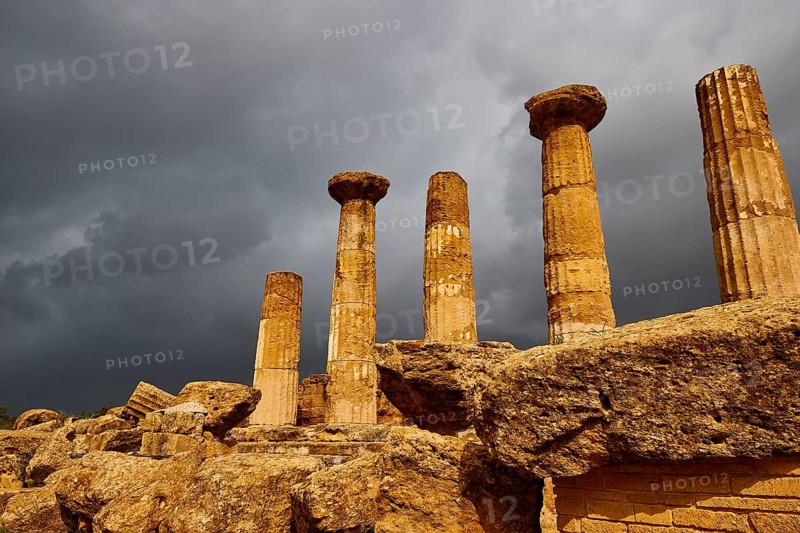Temple of Heracles, Five ancient columns against dark, looming clouds, Valley of the Temples, Valle dei Templi, Archaeological Site, UNESCO World Heritage Site, Agrigento, Sicily, Italy