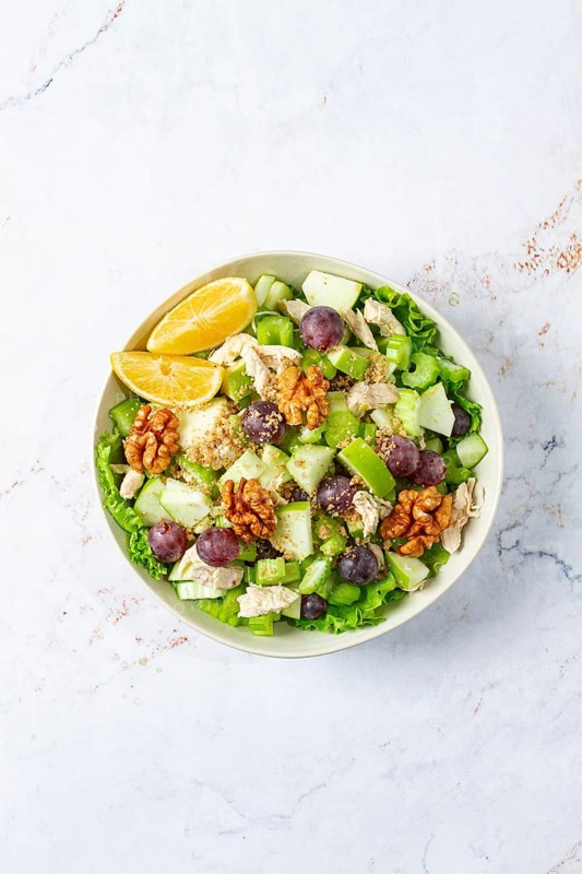 Fresh Waldorf salad, celery stalk with chicken, apple and walnuts, grapes, herbs, homemade, without people