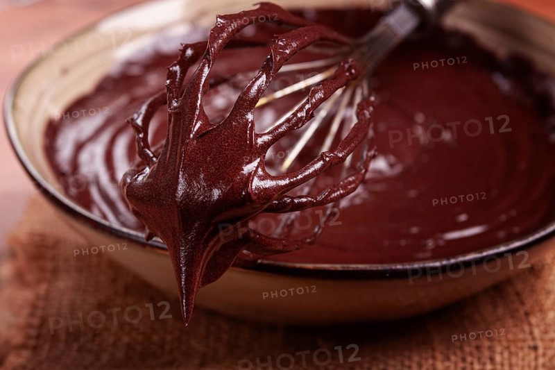 A bowl of chocolate dough, a whisk for whipping, baking, structure and consistency, homemade, top view, no people