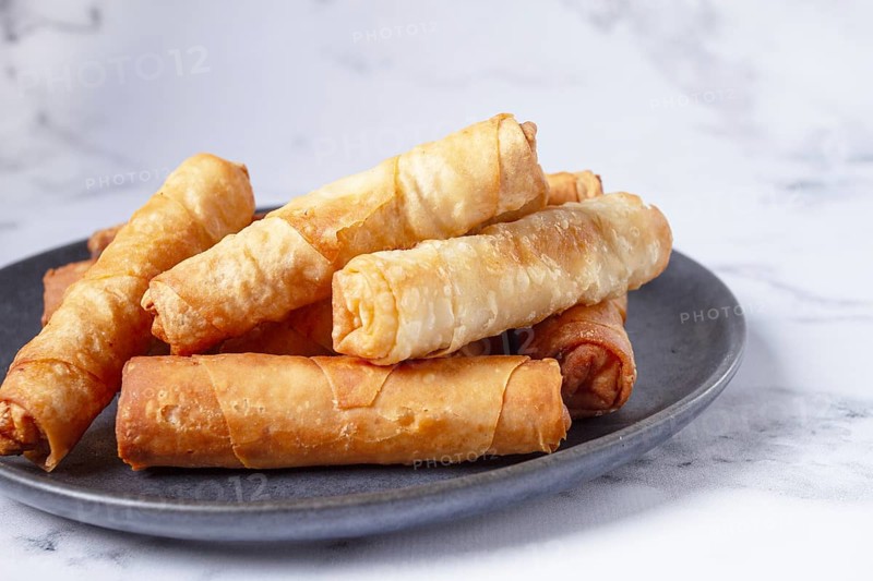 Fried spring rolls with cheese, on a plate, with cream sauce, no people