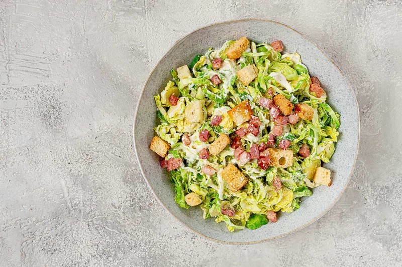 Brussels sprouts Caesar salad, with bacon and croutons, healthy food, homemade, no people