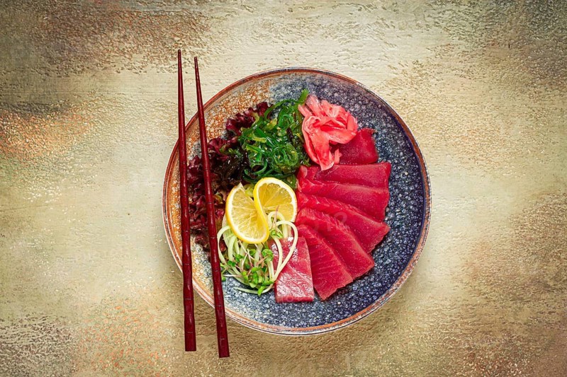Tuna sashimi with daikon and wakame salad, pickled ginger, in a bowl