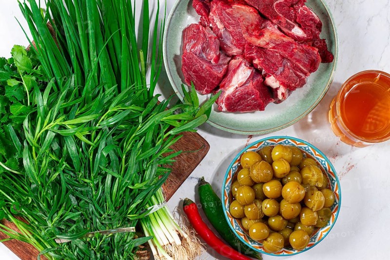 Ingredients for cooking chakapuli, canned tkemali, meat, herbs Georgian cuisine, top view