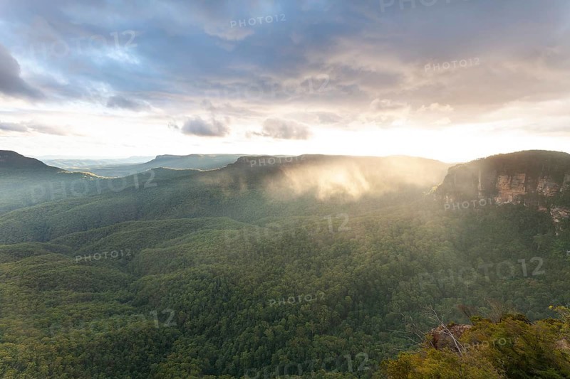 Evening sky with clouds of fog and setting sun at the Three Sisters at Echo Point in Katoomba, Blue Mountains, New South Wales, Australia