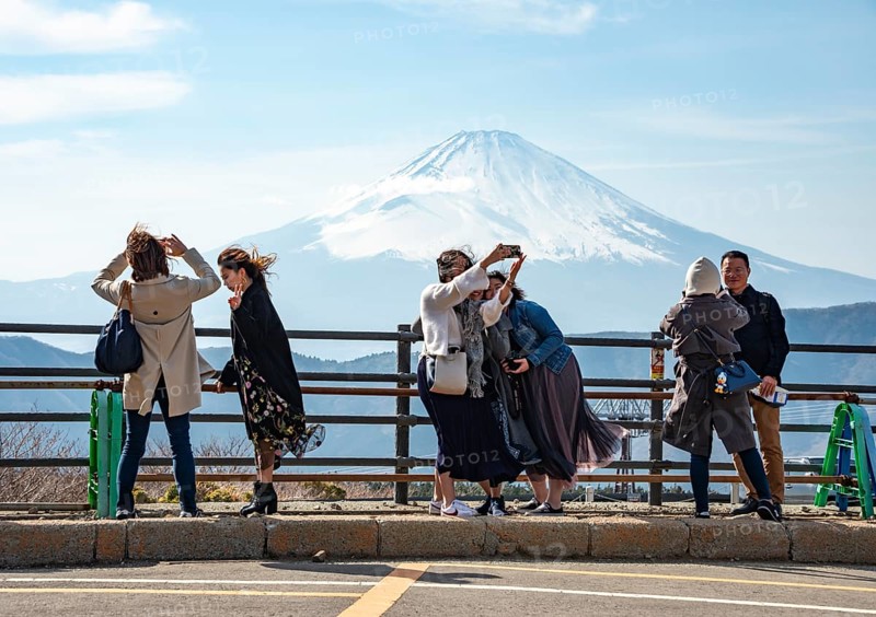 Tourists enjoy the view and take pictures, view of the snow-covered summit of Mount Fuji volcano in spring, ÅŒwakudani, Hakone, Japan