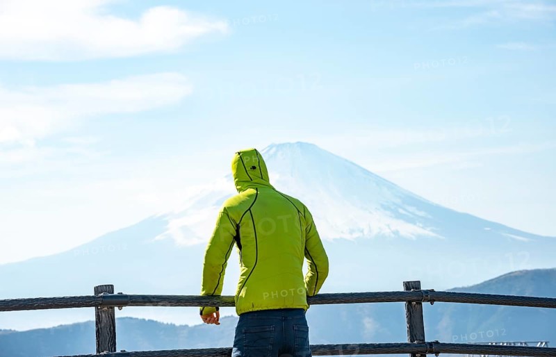 Tourist enjoying the view of the snow-covered summit of Mount Fuji volcano in spring, ÅŒwakudani, Hakone, Japan