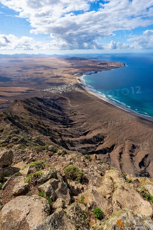 Castillejo viewpoint, view from the Risco de Famara cliffs to the coast and the sea with the Famara beach, Playa de Famara, Lanzarote, Canary Islands, Spain