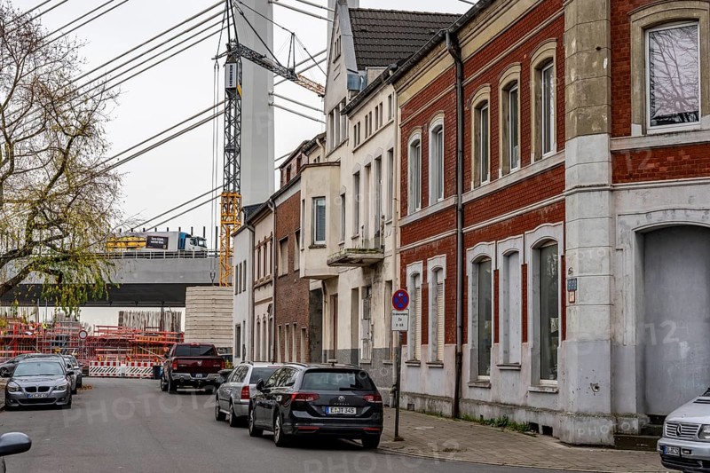 Residential buildings, directly on the A40 Neuenkamp bridge, in Duisburg-Homberg, pillars and cables of the new motorway bridge across the Rhine near Duisburg, construction phase of the 2nd bridge structure, North Rhine-Westphalia, Germany
