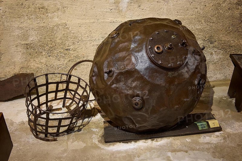 An ancient sea mine next to a metal basket on a concrete floor, War Museum, Military Museum, Tunnel Museum, Lakki, Leros, WW2, Dodecanese, Greek Islands, Greece