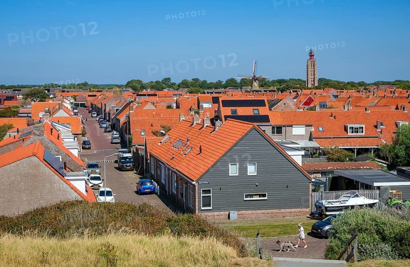 Westkapelle, Zeeland, Netherlands - Westkapelle. In the background the lighthouse 't Hoge Licht and the windmill De Noorman. Houses with red roofs
