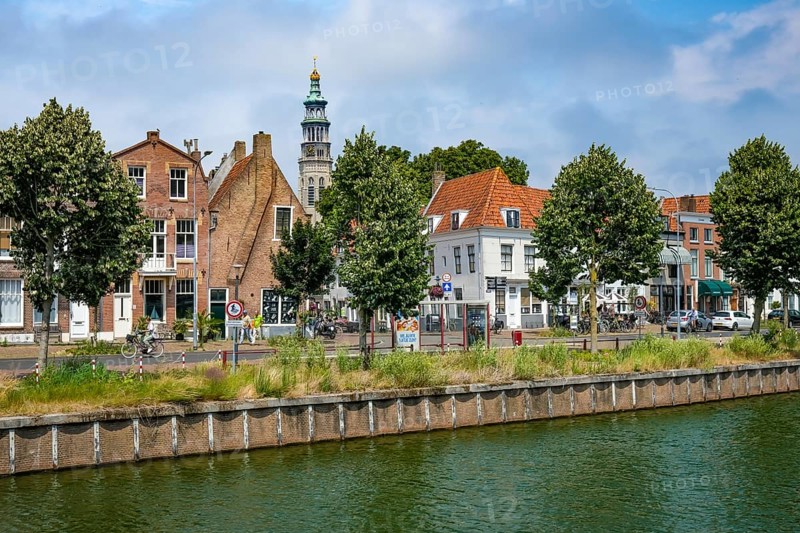 Middelburg, Zeeland, Netherlands - Townhouses on the Turfkaai at the Binnenhaven in the historic city centre. At the back is the Tall John Abbey Tower, a restored church tower from the 14th century with 207 stone steps leading to a viewing gallery