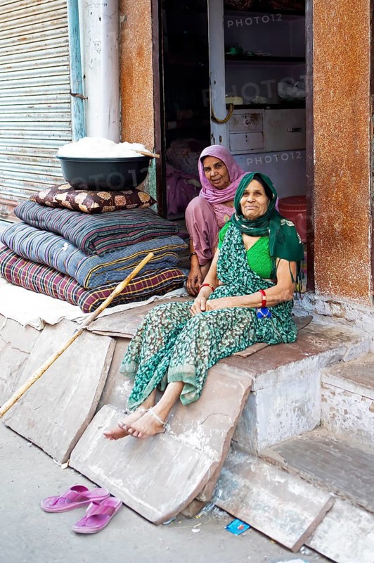 Indian tailors sit next to a tub of cotton in the old city centre, Bundi, Rajasthan, India