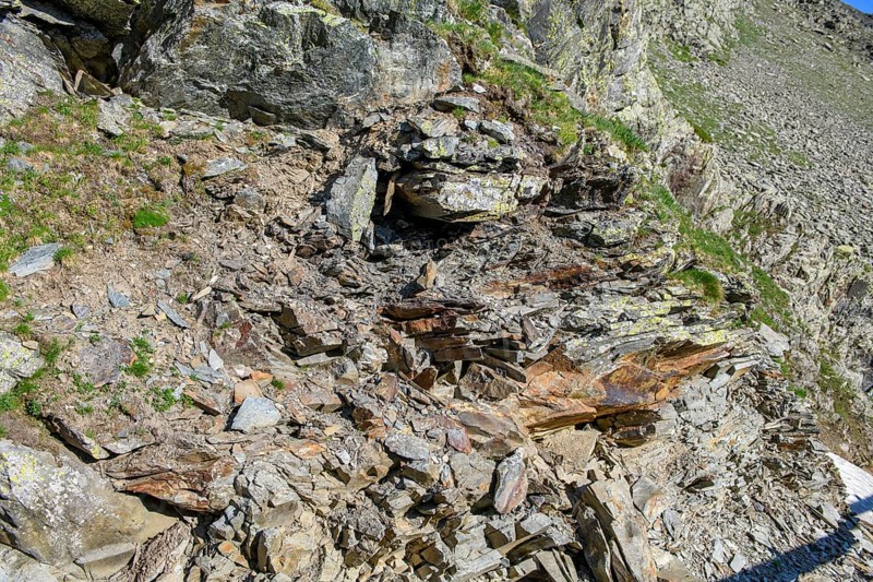 Small pieces of rock eroded rock lying open on mountainside of rocky peak in Alps, Italy