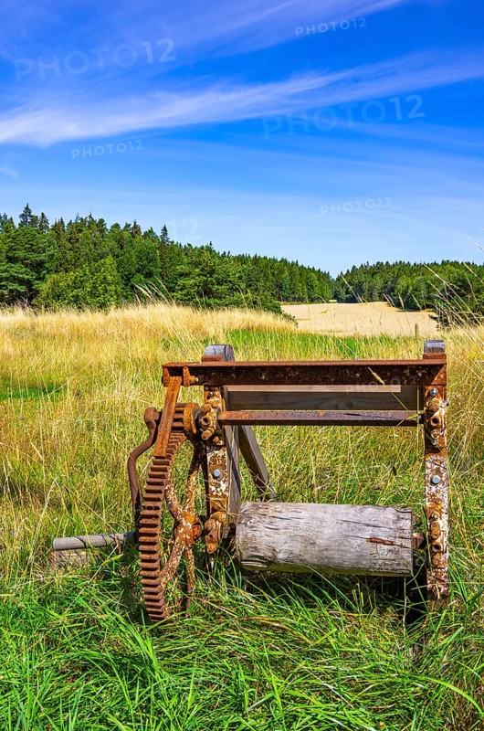 Traditional historical and rusty weathered agricultural equipment in a rural setting near Sunnersberg near Lidköping, Västergötland, Västra Götalands län, Sweden