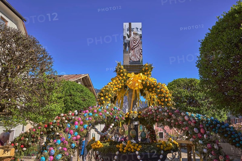 Easter fountain, Easter decoration, blown out coloured Easter eggs, trees, historical buildings, blue sky, cloudless, Florianiplatz, Bad Reichenhall, district Berchtesgadener Land, Bavaria, Germany