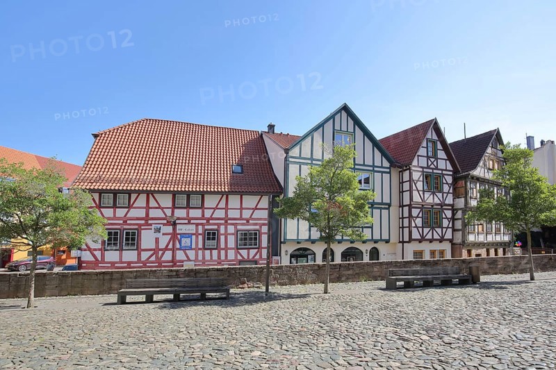 Colourful half-timbered houses, red, green, brown, empty benches, churchyard, Schmalkalden, Franconia, Thuringia, Germany