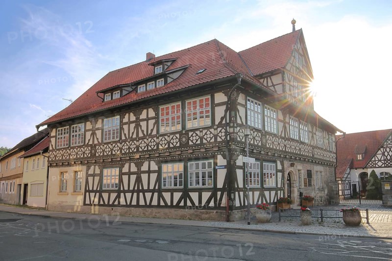 Historic official residence built in 1665 with backlight, half-timbered house, hipped roof, Themar, fieldstone, Thuringia, Germany