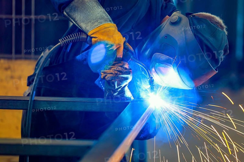 Germany - Theme photo metal industry. An industrial welder welds a workpiece