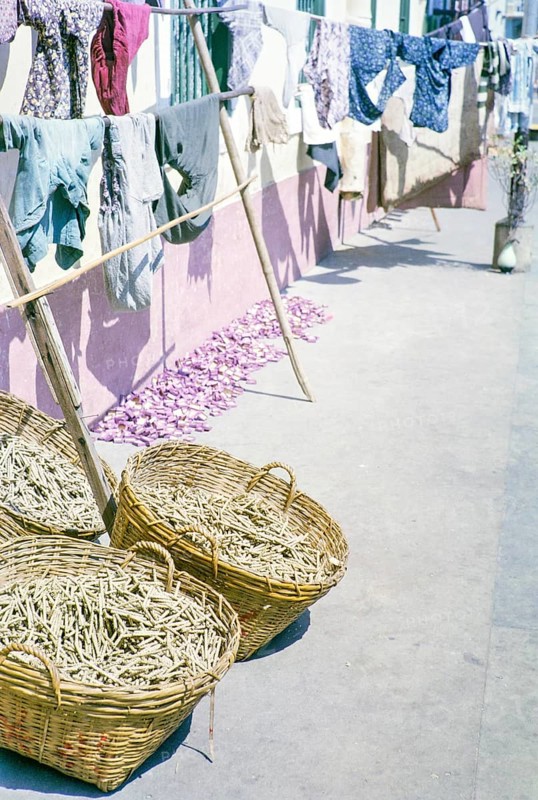 Clothes handing out to dry with baskets of what is thought to be clothes pegs, clothespins, Macau, Asia 1964
