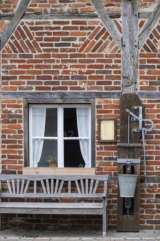 Half-timbered house, half-timbered façade with bench and swing pump, Borken-Gemen Heritage House, Münsterland, North Rhine-Westphalia, Germany