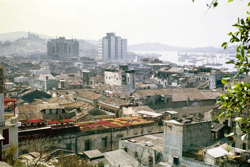 View over rooftops of high density buildings in city centre to Our Lady of Penha Chapel on hilltop from Monte Fort, Macau, Asia 1964