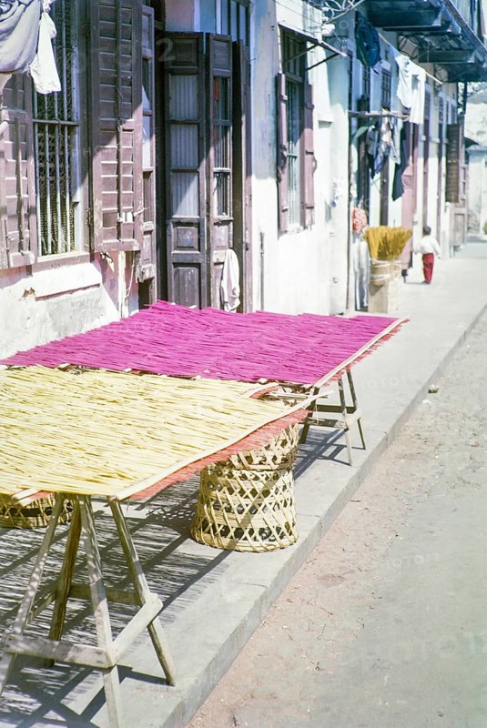 Woven bamboo mats laid out on trestle table outside traditional building, Macau, Asia 1964