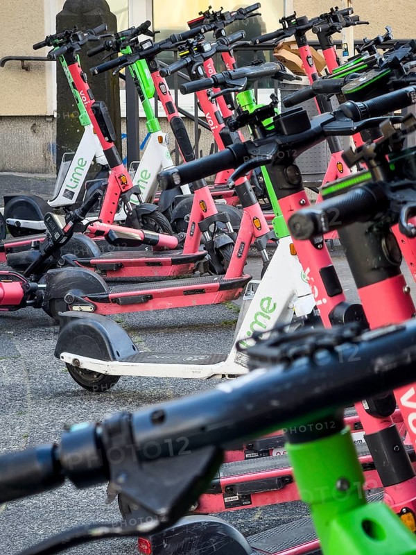 Many rental e-scooters parked on a pavement in Wuppertal, Germany