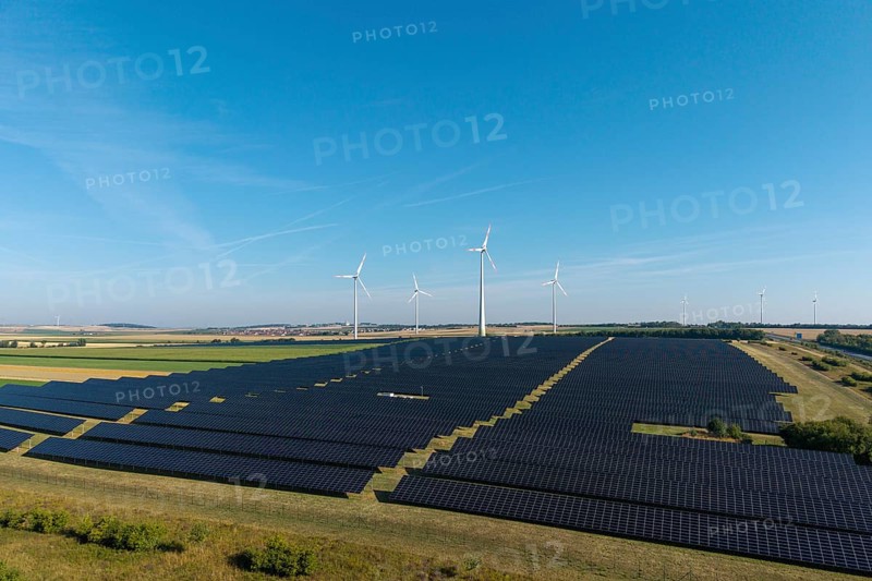 Large-scale solar panels and wind turbines across a wide agricultural field, near Kitzingen, Lower Franconia, Bavaria, Germany