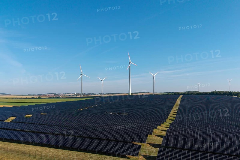 Solar panels and wind turbines on a wide field under a clear sky, near Kitzingen, Lower Franconia, Bavaria, Germany